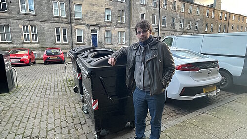 Cllr Jack Caldwell standing next to a broken bin on Pitt Street