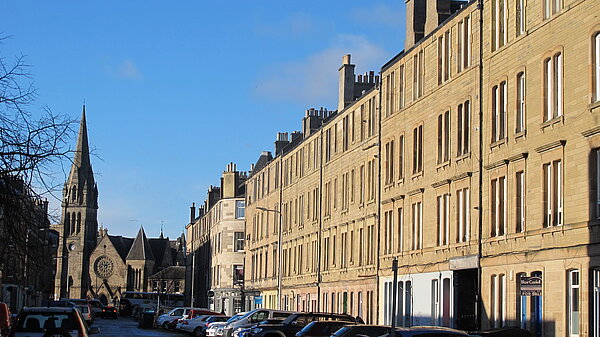 Iona Street with tenements on the right and a church in the background