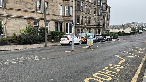 A road with tenements in the background.