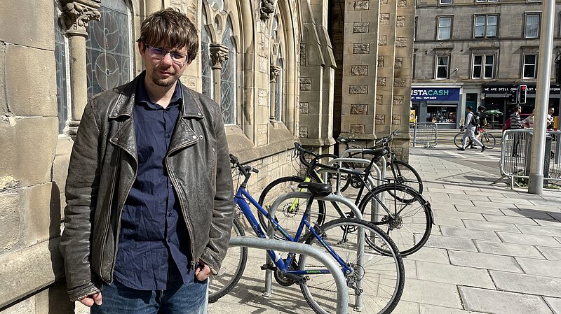 Jack Caldwell standing next to bikes chained to a bike rack