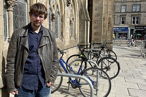 Jack Caldwell standing next to bikes chained to a bike rack