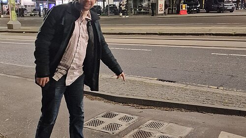 Jack pointing at a utility cover at night