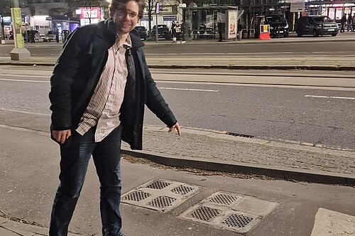 Jack pointing at a utility cover at night