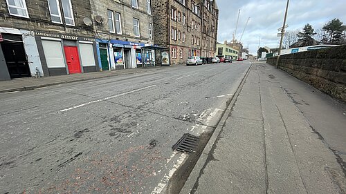 A street with a row of tenements in the background