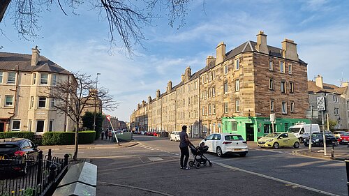 An individual with a pram trying to cross Easter Road