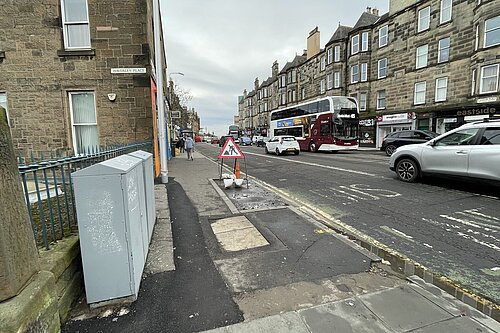 London Road looking eastwards from Abbeyhill, with a pavement in the foreground and road in thr background.