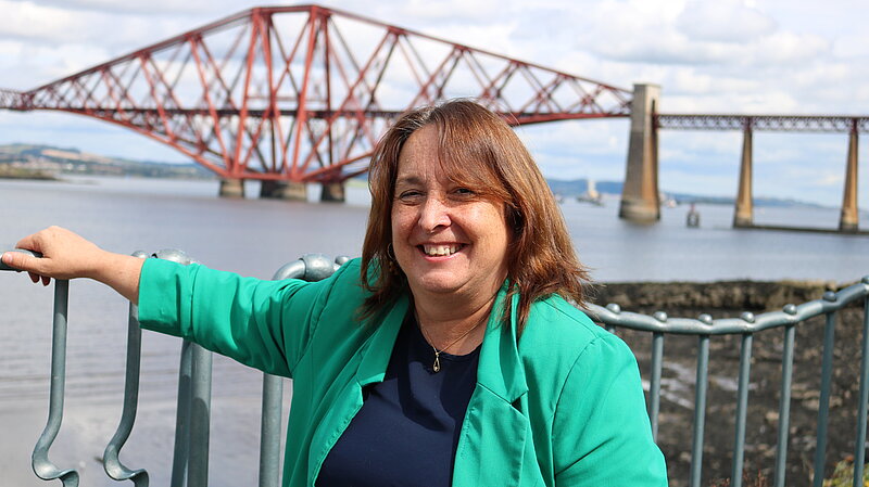 Christine Jardine standing in front of the Forth Rail Bridge