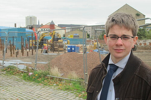 Jack Caldwell standing in front of a fenced-off building site in Bonnington.