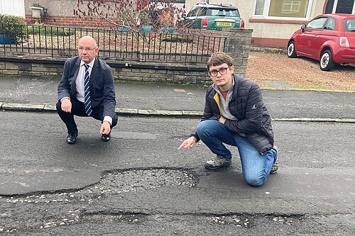 Councillors pointing at a pothole on Parkgrove Drive