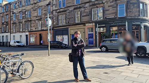 Councillor Jack Caldwell standing in front of a crossing on Dalmeny Street with cars in the background.