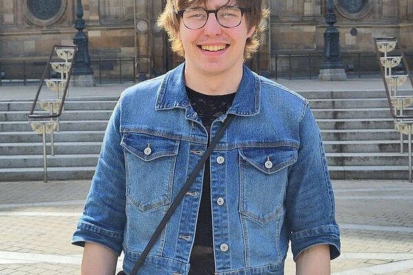 Artie standing in front of an Edinburgh University building at Bristo Square