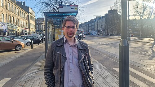 Jack Caldwell standing in front of a bus stop with a cycle lane at either side