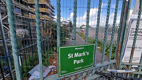 A green sign reading "St Mark's Park" with a fence in front of it